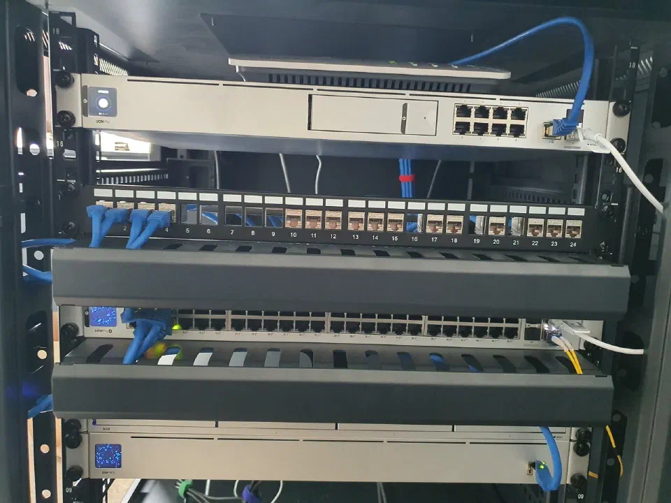 Aufgeräumtes Netzwerkrack mit beschriftetem Patchfeld, Switch und geführten Kabeln